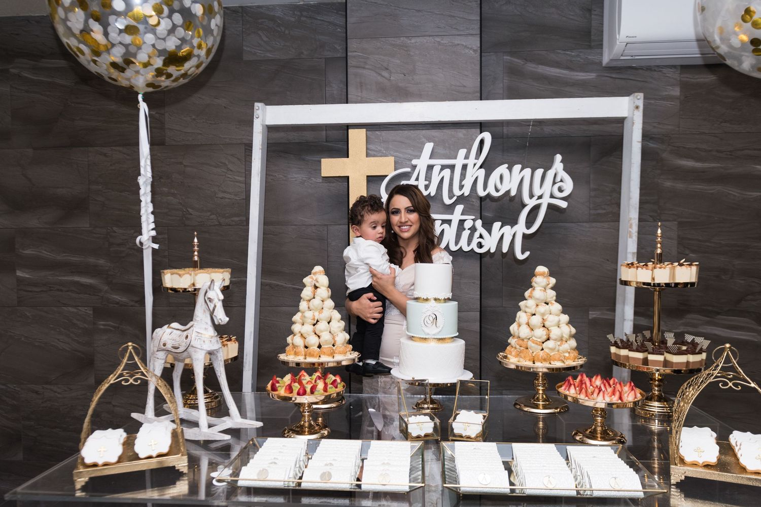 Wedding dessert table setup with cream and gold theme features elegant cakes and cupcakes on tiered stands.