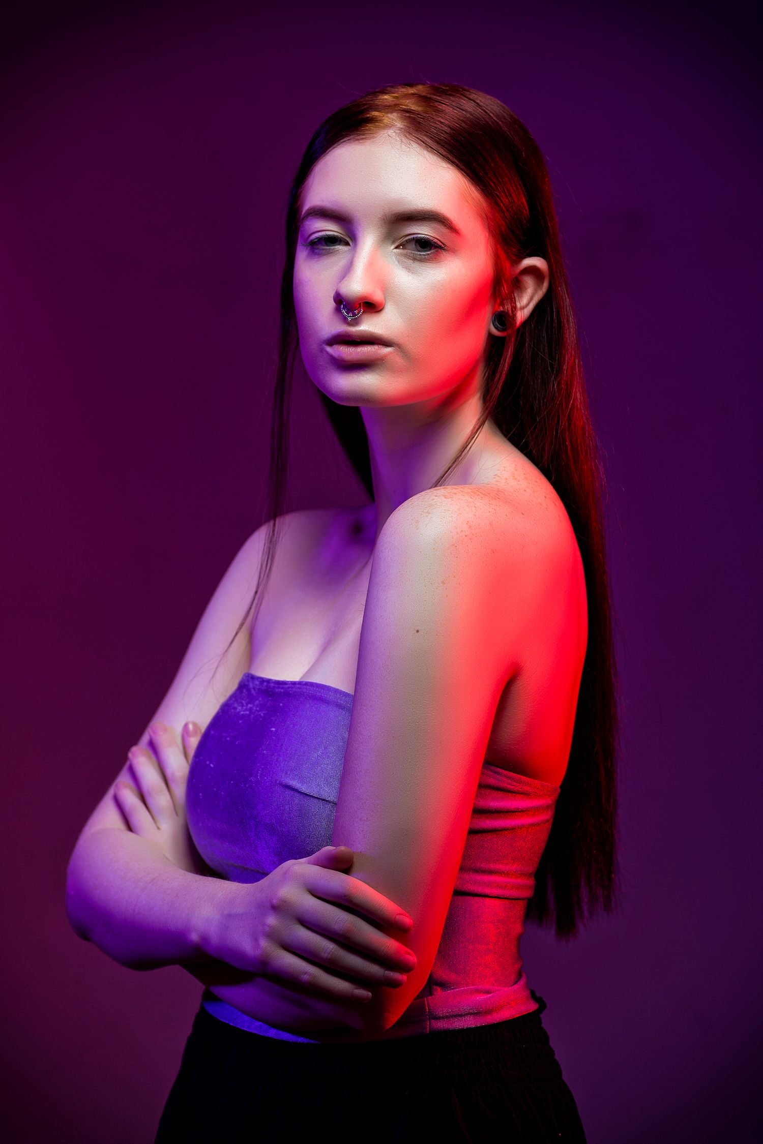 Artistic portrait series with dramatic red and purple lighting creating a split color effect on the model against dark background.