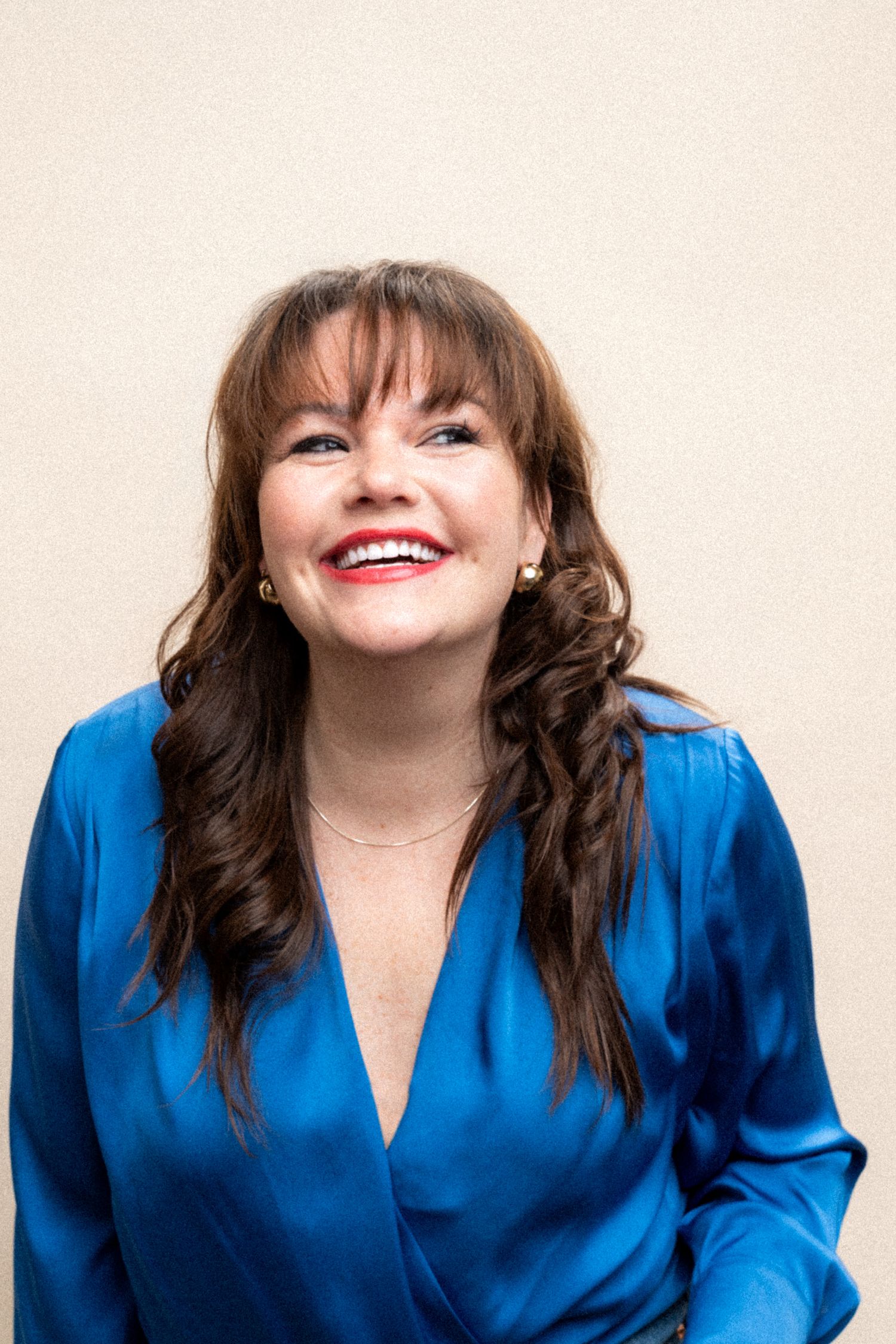 Portrait sequence showing joyful expressions and laughter while wearing a bright blue top.