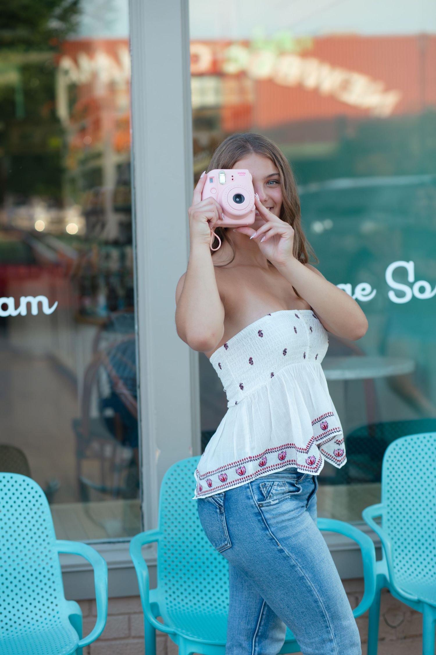 A sequence of photos shows someone in a white top and jeans dancing and posing playfully in front of turquoise chairs.