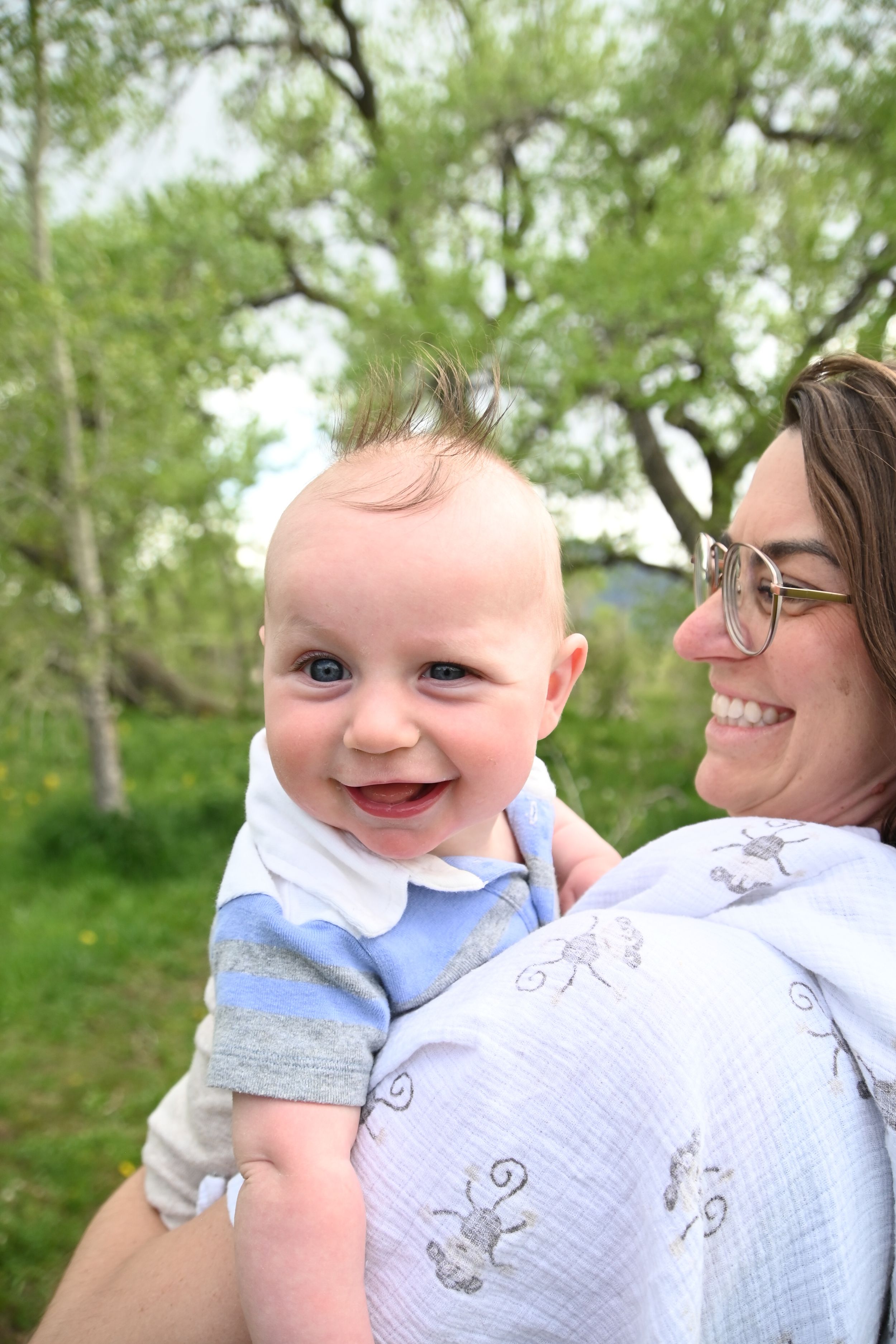 A joyful scene outdoors with spring trees in the background on a sunny day.