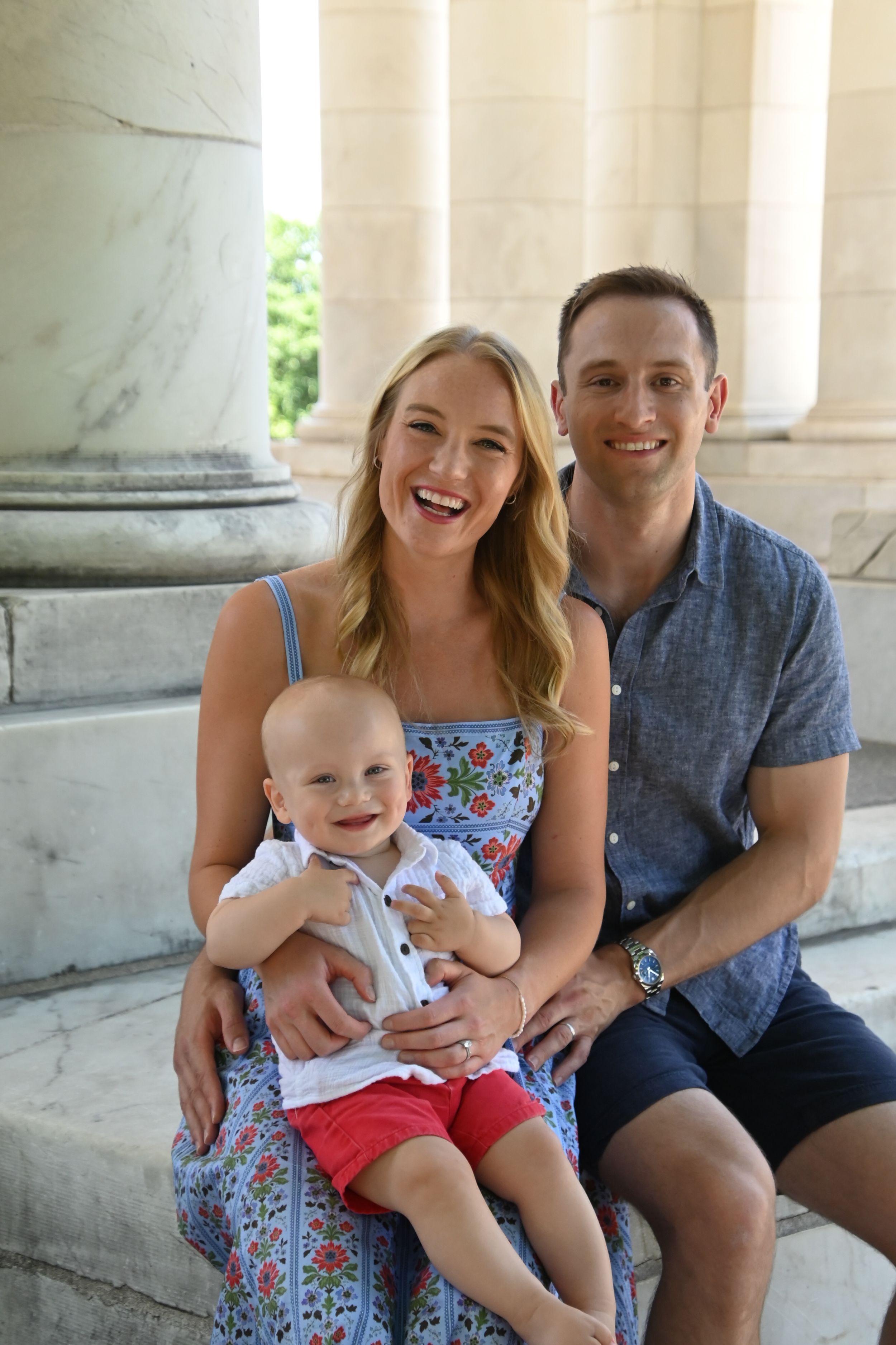 Family portrait series with three casual outdoor poses sitting by marble columns.
