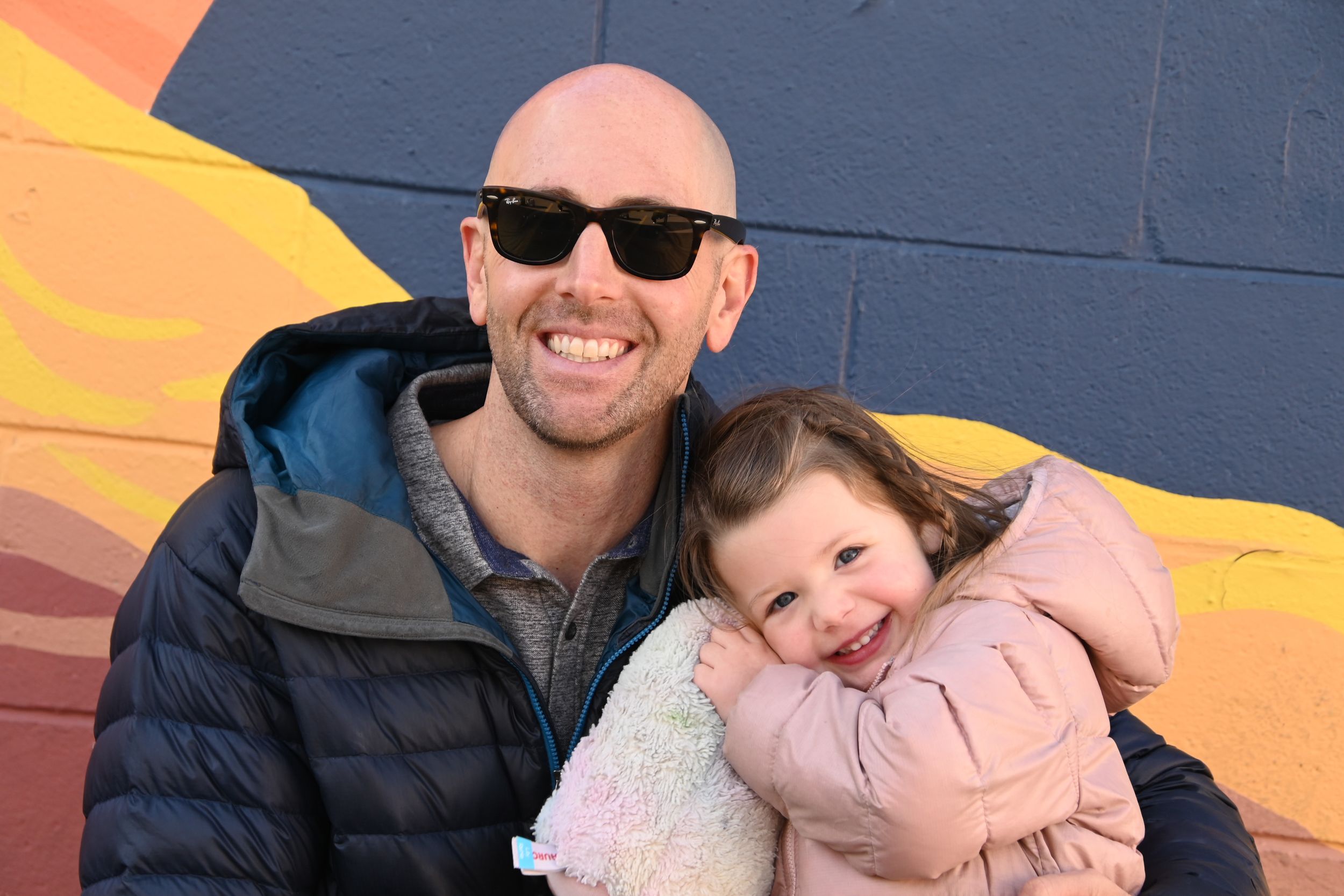A heartwarming series of photos showing a parent and child bonding against a colorful wall backdrop.