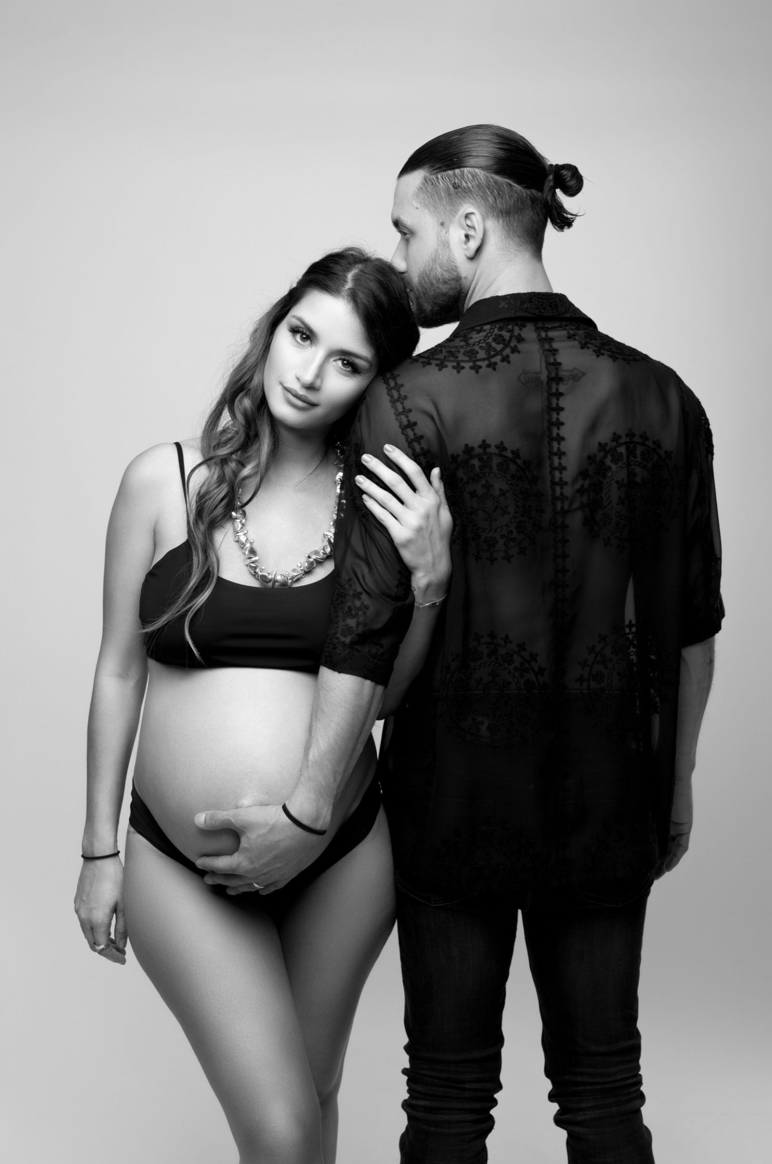 A black and white fashion photo series showing artistic poses and interaction between two models in monochrome styling.