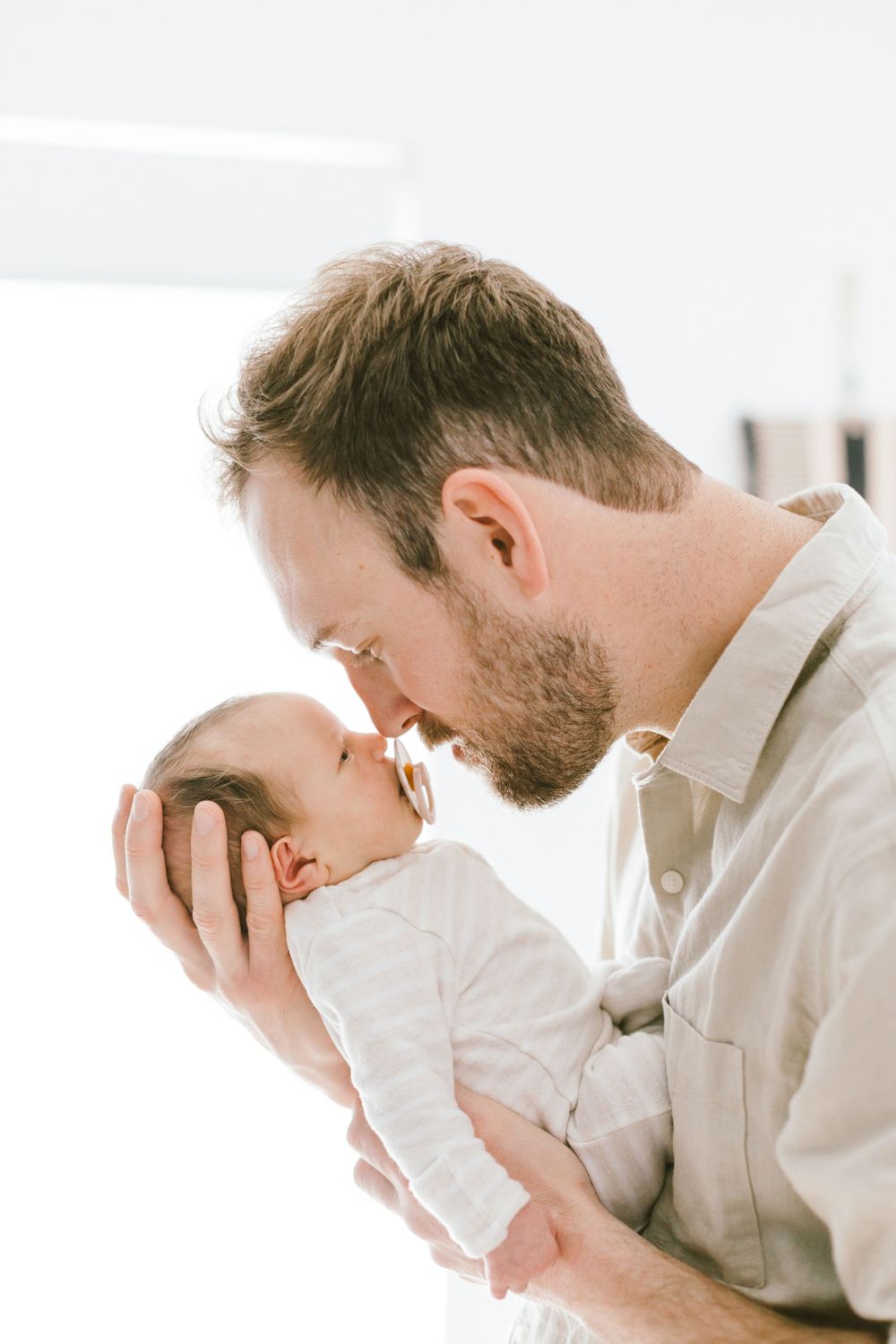 Intimate close-up of parent and infant sharing a gentle moment together.