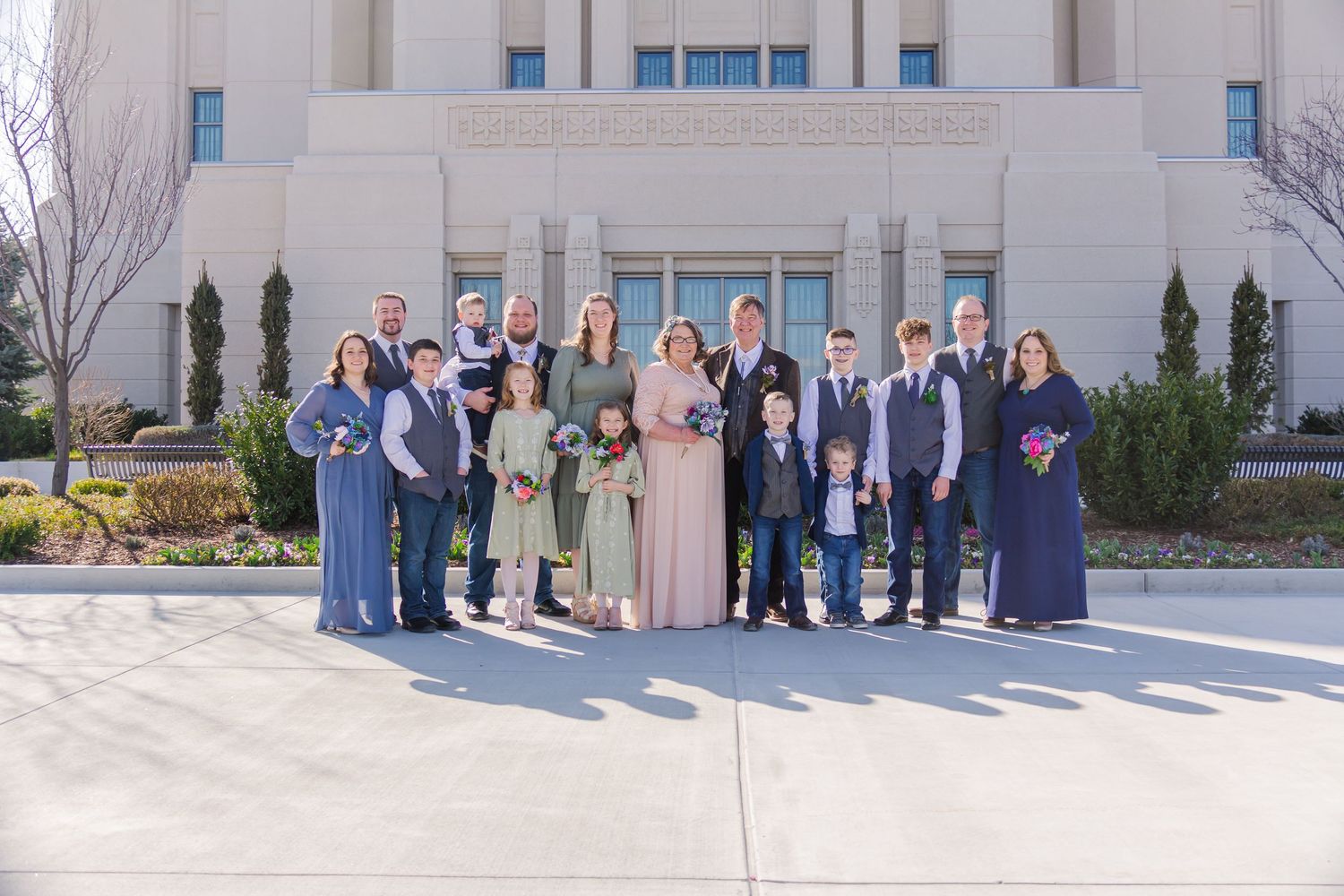 Large group photo taken outside modern building with columns.