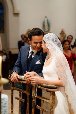 A happy couple shares an intimate moment during their Catholic church wedding ceremony.