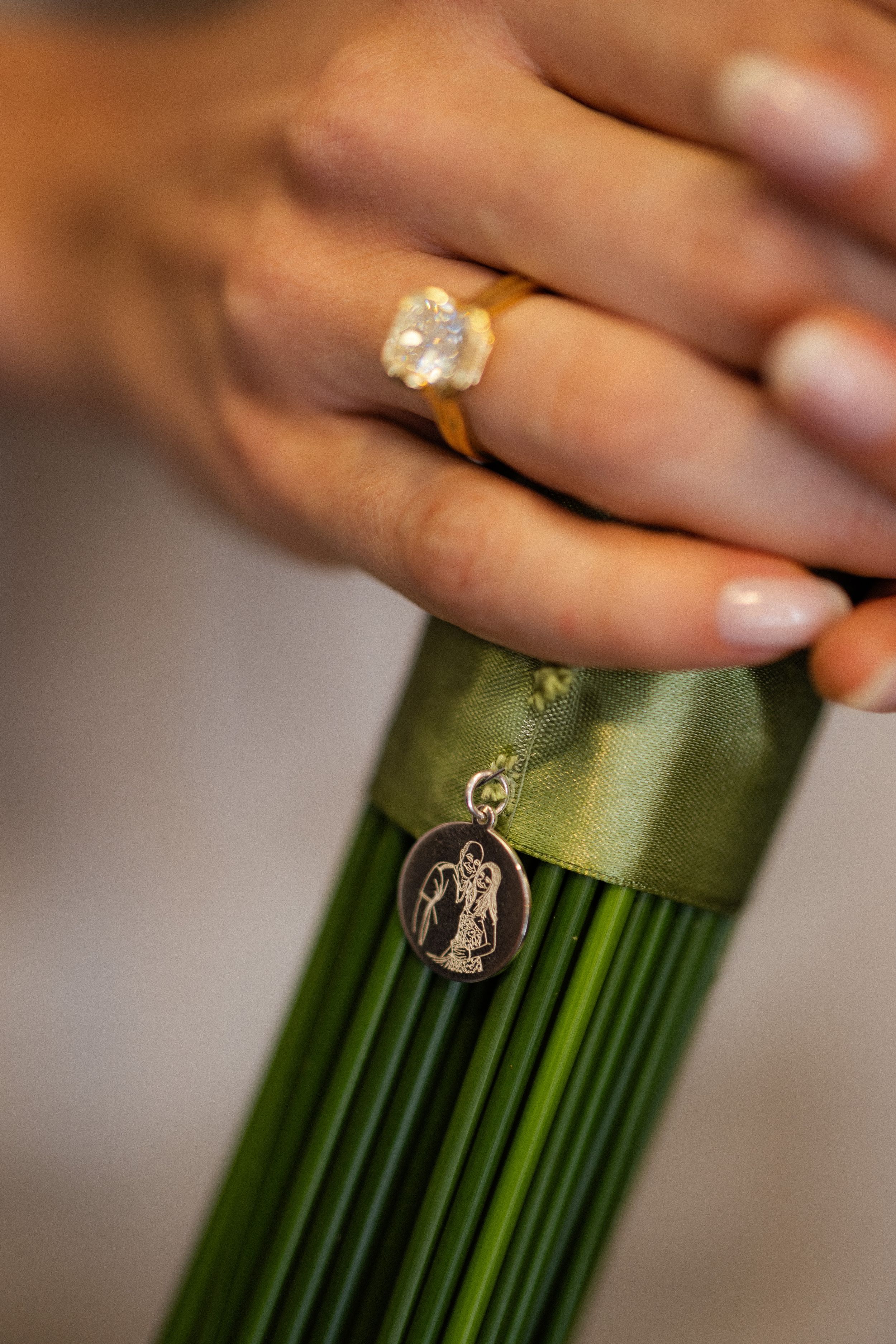 Close-up detail of elegant green floral bouquet wrapping with delicate charm decorations.