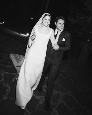 A vintage black and white wedding photograph showing a couple in formal attire on their special day.