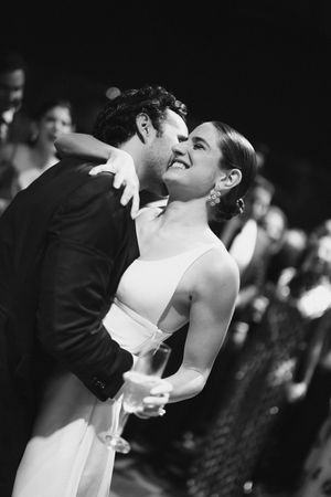 A romantic black and white photo of a couple dancing during their wedding reception.