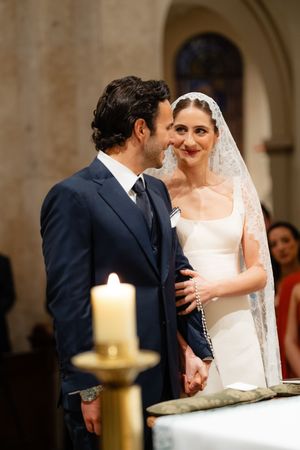 A sequence of intimate wedding ceremony moments in a church with a candle in the foreground.