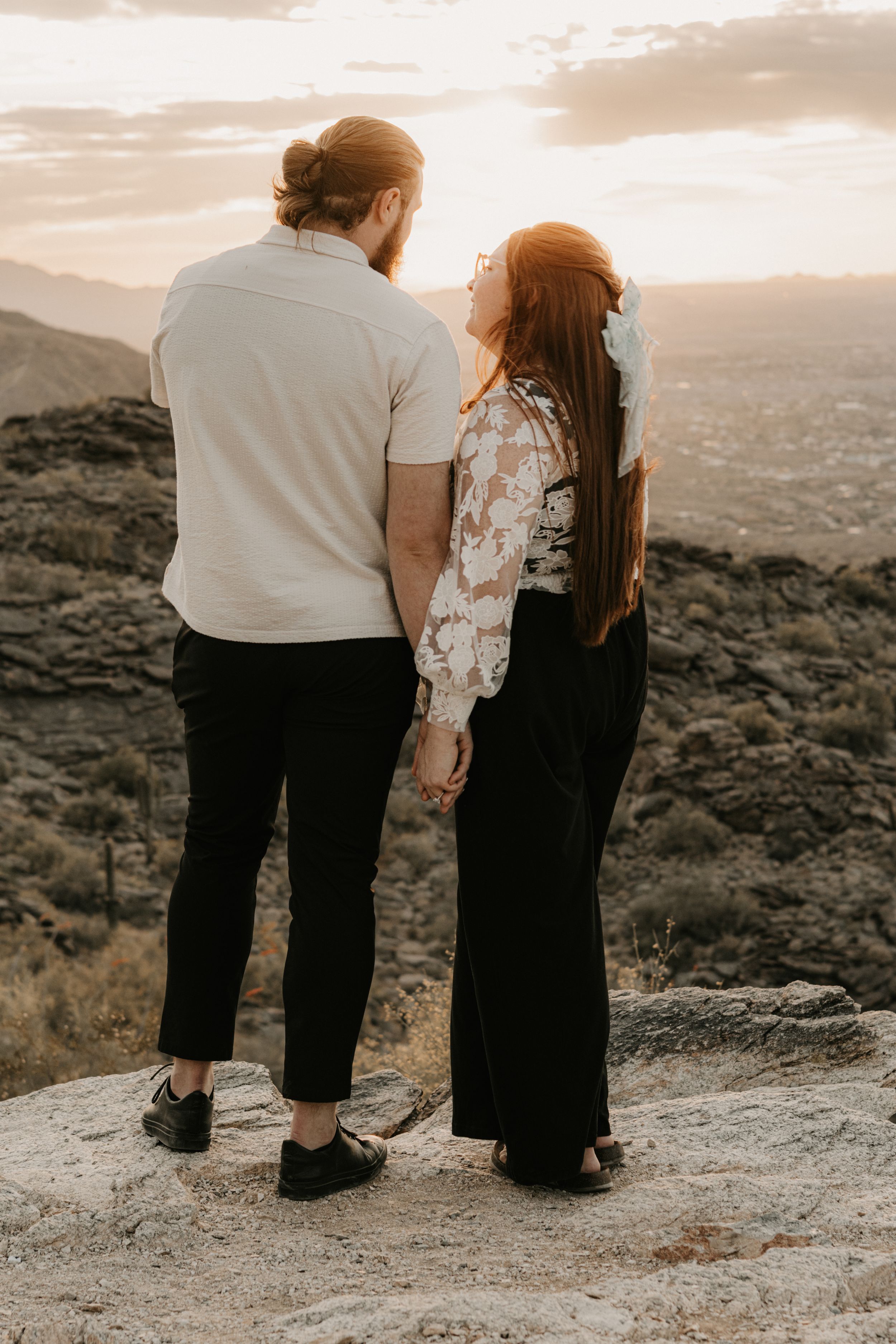 Romantic engagement photography featuring desert mountains and warm natural light.