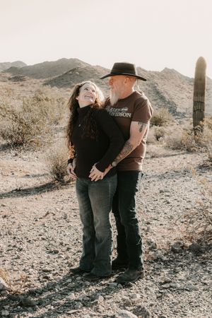 Couple walking together through the desert landscape during sunset in Phoenix.