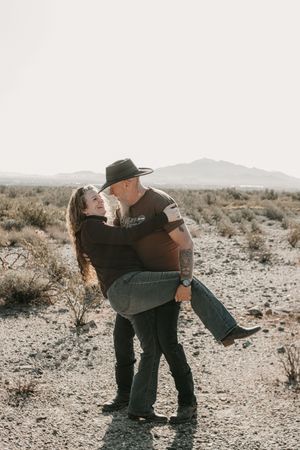 Couple laughing together during a warm and moody Arizona couples session.