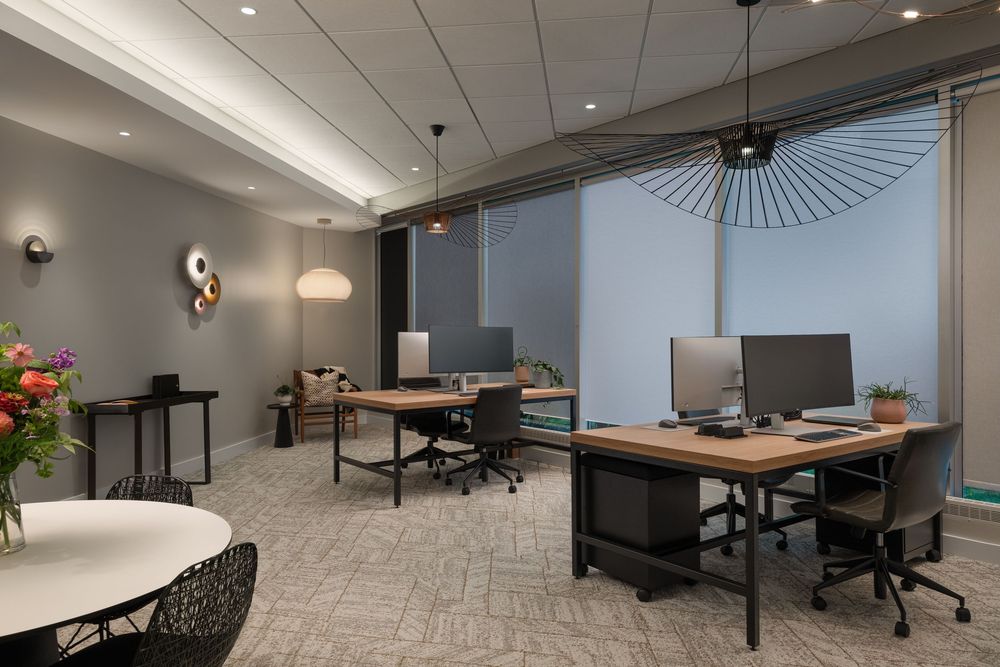 Modern office space features open layout with conference room, pendant lighting, and contemporary furnishings.