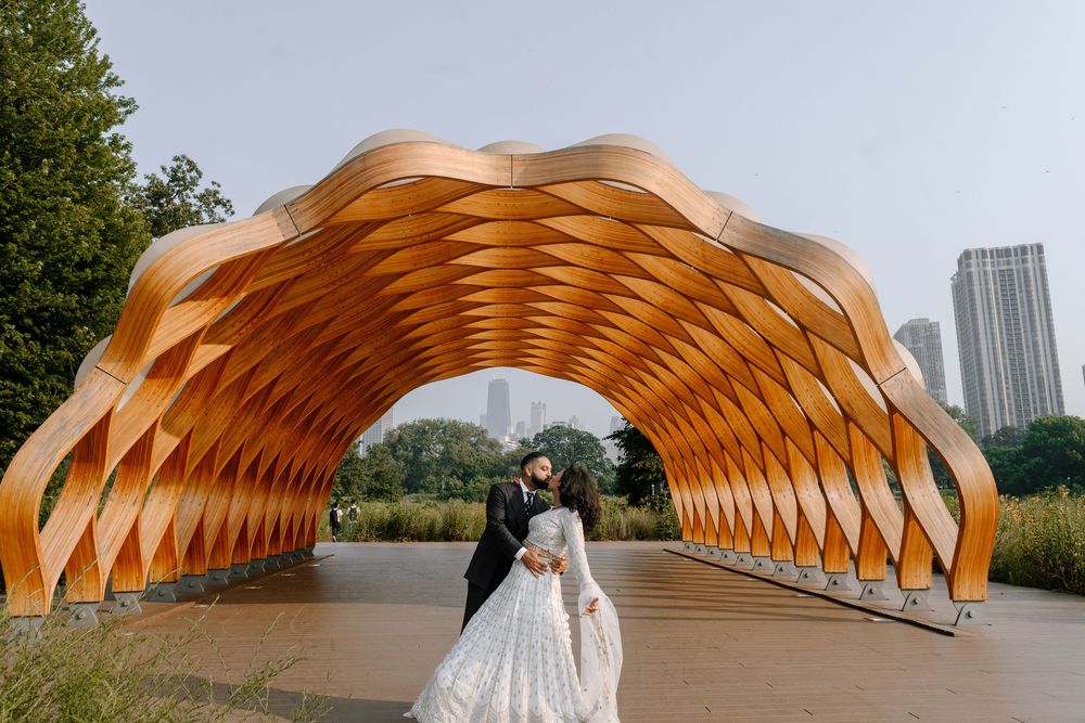 Orange wooden archway pavilion with geometric pattern design creates striking architectural element in outdoor setting.