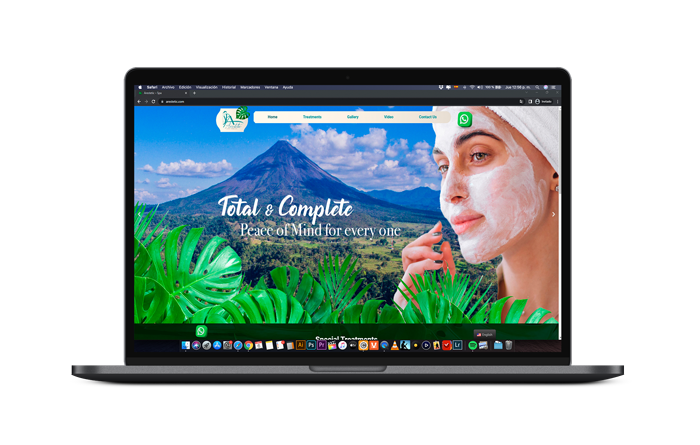 Laptop displaying tropical website design with mountain volcano landscape.