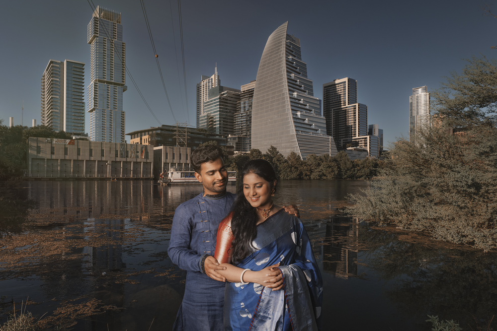 A couple poses at dusk with the Atlanta skyline featuring modern skyscrapers and architectural landmarks in the background.