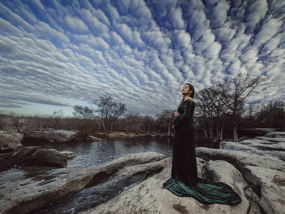 A panoramic sequence of cloud formations above a winter landscape with snow-covered ground and bare trees at dawn.