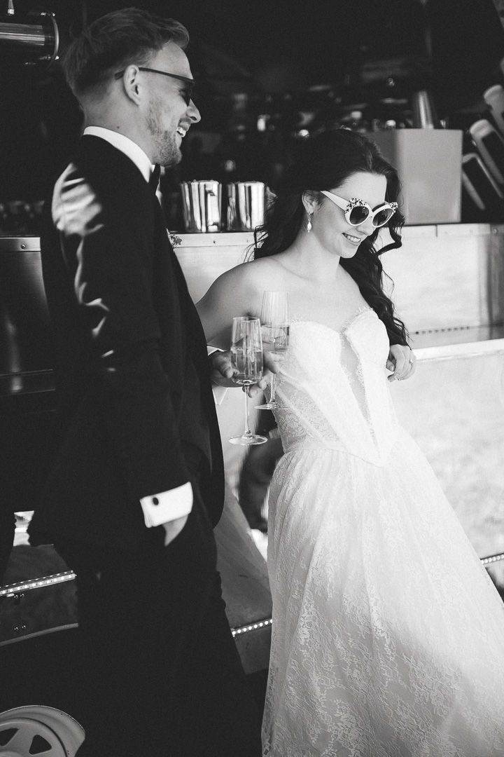 Black and white wedding photo series capturing candid dance moments between a bride in a lace gown and groom in formal attire.