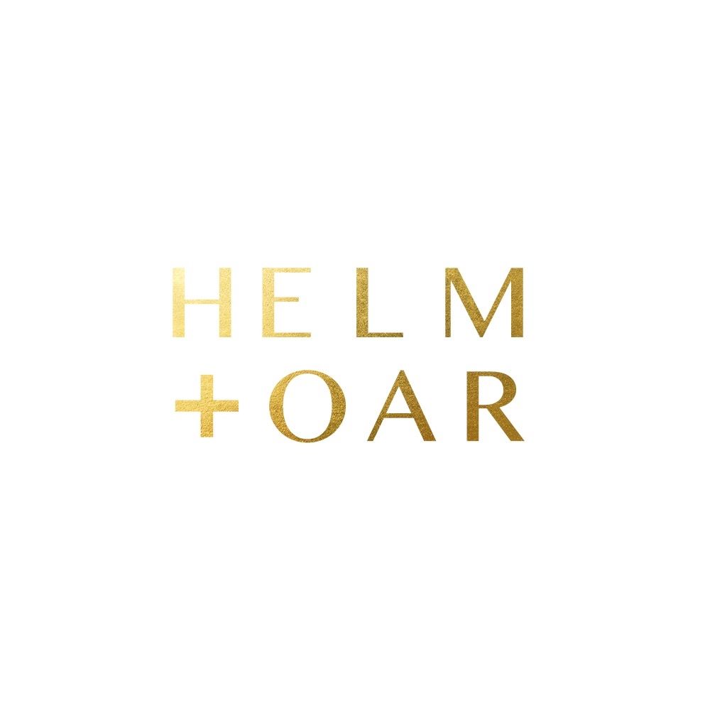 Minimalist gold logo design for Helm + Oar featuring stylized text in metallic finish on white background.