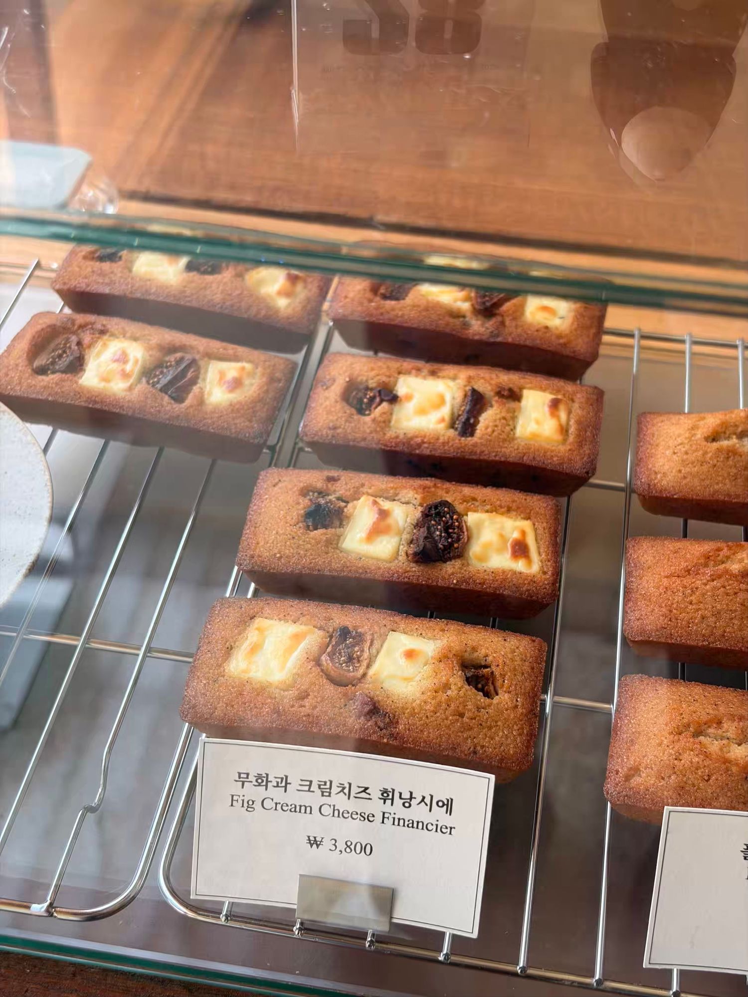Fig Cream Cheese Financier pastries displayed in a Korean bakery case, priced at 3,800 won.
