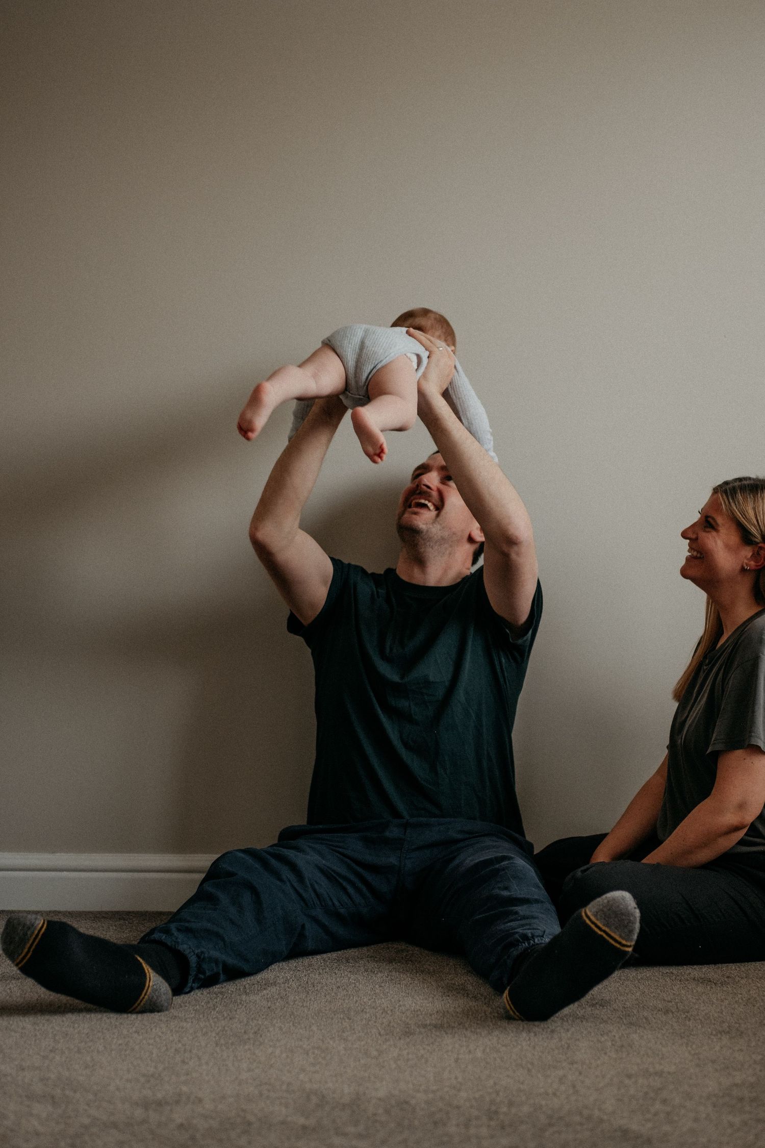 Dad lifting baby up at home in North Shields