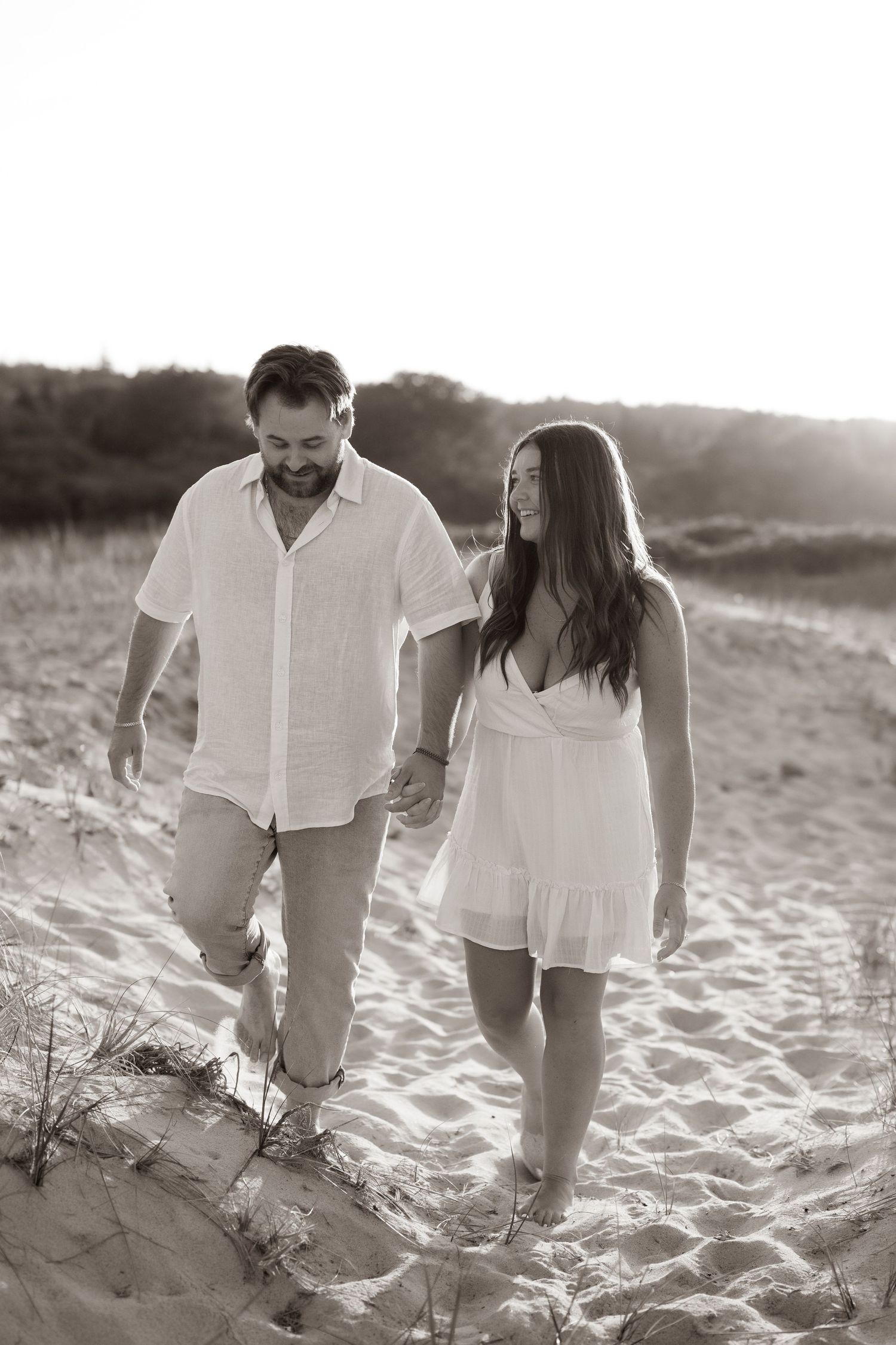 Couple laughing together during a golden hour engagement session a the beach in Atlantic Canada