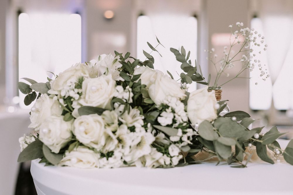 Eleganter weißer Brautstrauß mit Rosen, Schleierkraut und Eukalyptus.