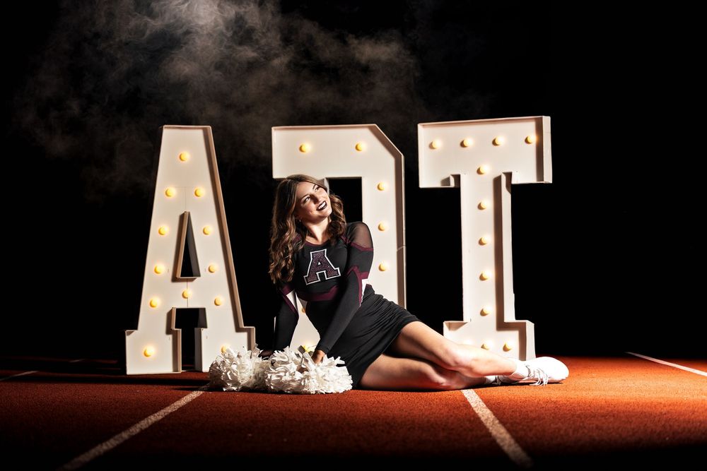 Illuminated marquee letters spelling 'ADT' displayed against a dark background in a theatrical setting.