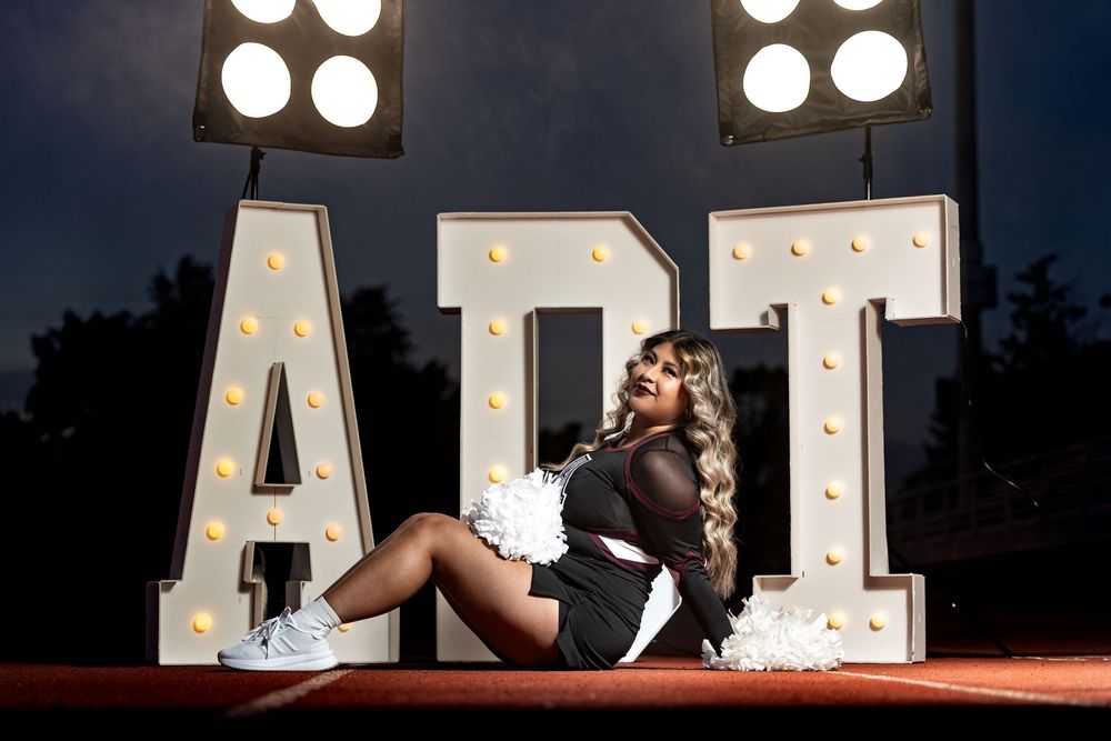 Illuminated marquee letters spelling 'ADT' shine brightly against a dark background at night.