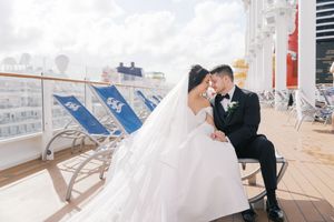 Bride and groom share a romantic moment on a cruise ship deck, with the wedding dress flowing in the breeze.