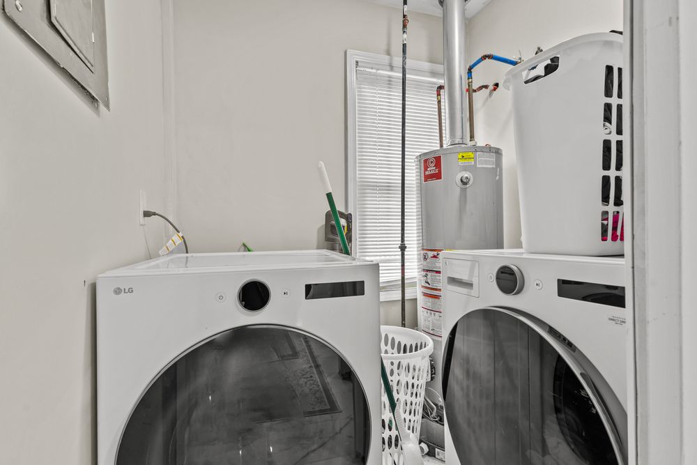 Laundry room with LG front-load washer and dryer plus a water heater in a compact white space.