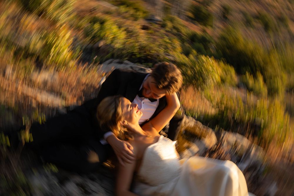 Artistic swirling blur effect captures bride and groom in an intimate romantic outdoor moment.