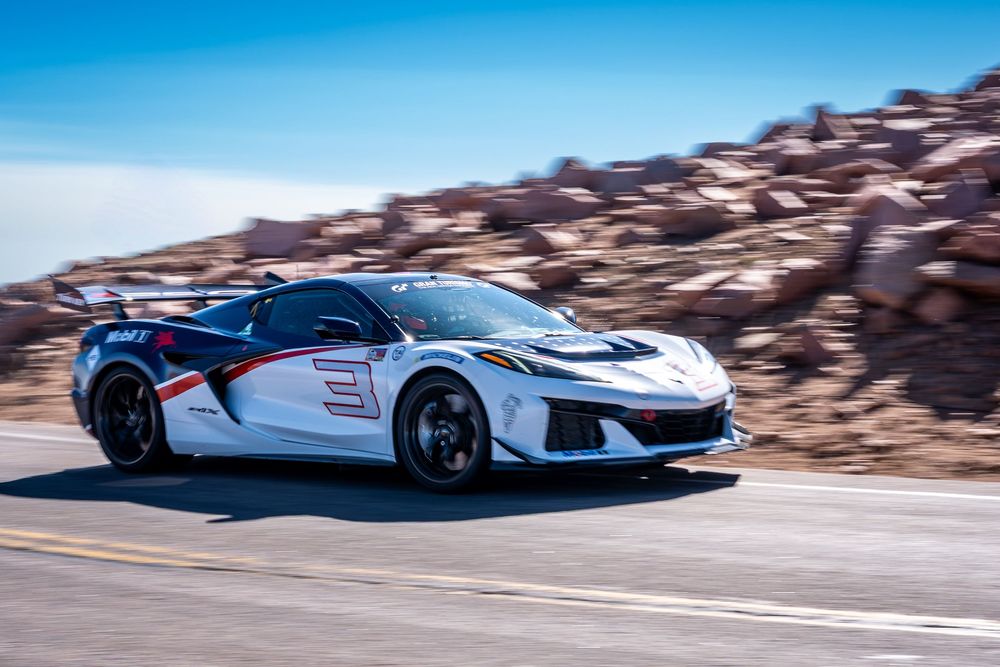 White Corvette ZR1 race car with number 3 speeding on a mountain road at Pikes Peak Hill Climb.