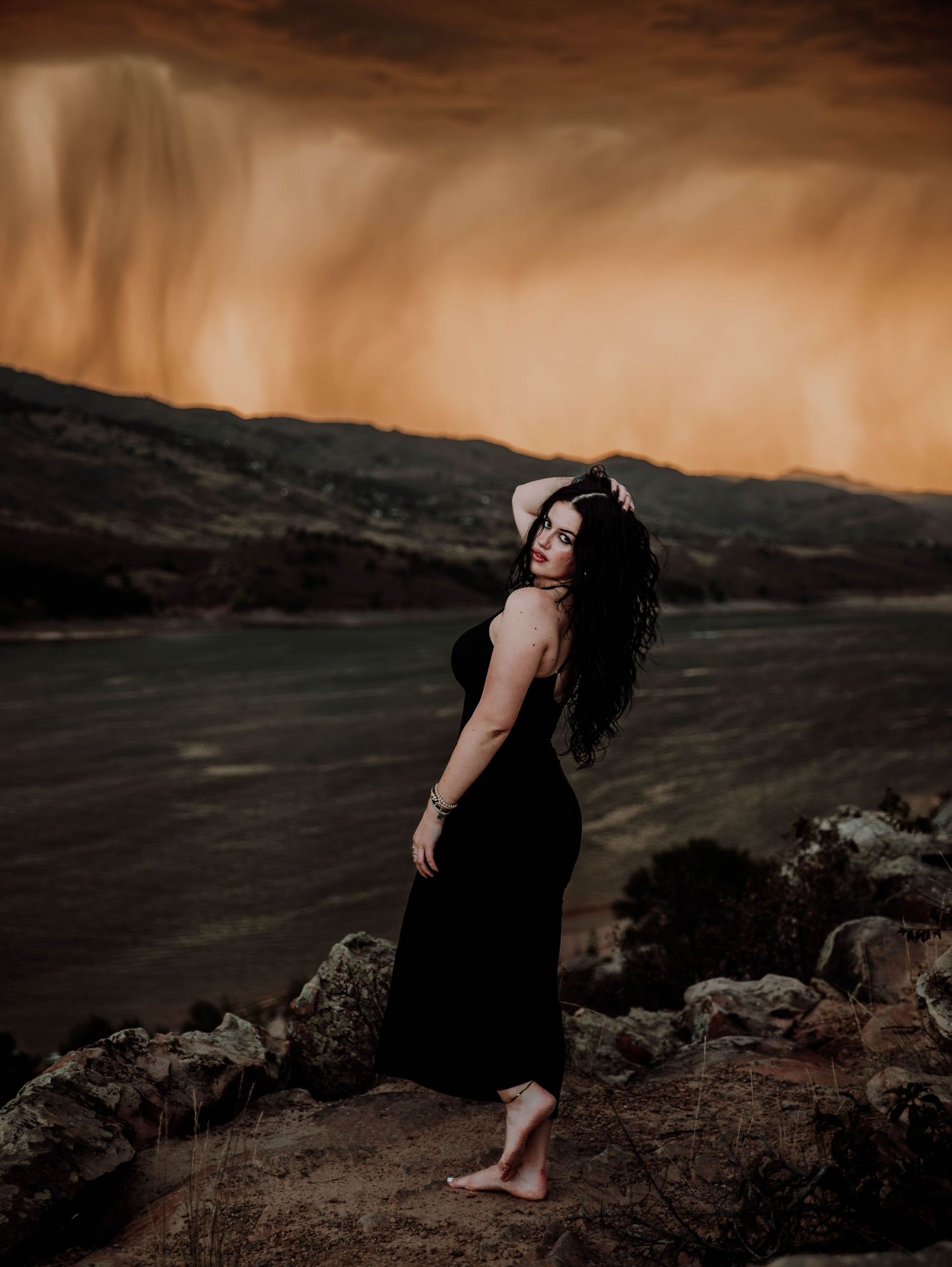 Woman poses in front of dramatic, cinematic sky for portrait and modeling photos in Fort Collins, Colorado