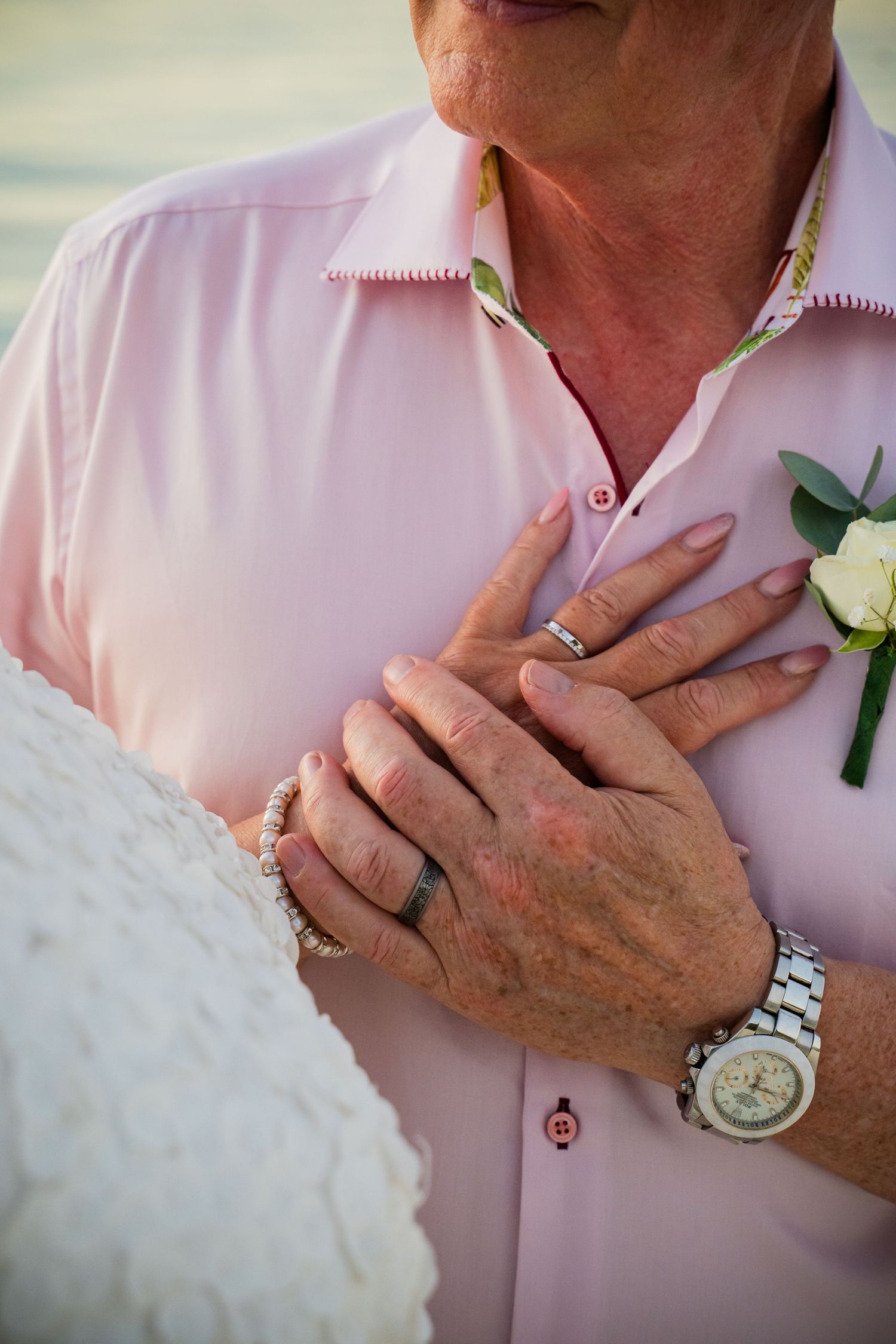 Close-up of bride and groom's hands and wedding rings during Mauritius beach wedding