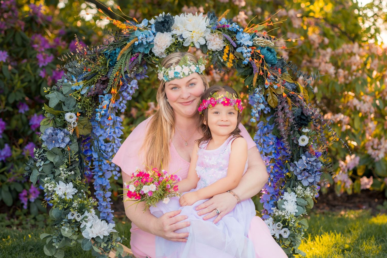 Smiling mother and daughter wearing matching flower crowns during an outdoor portrait session in Amherstburg.