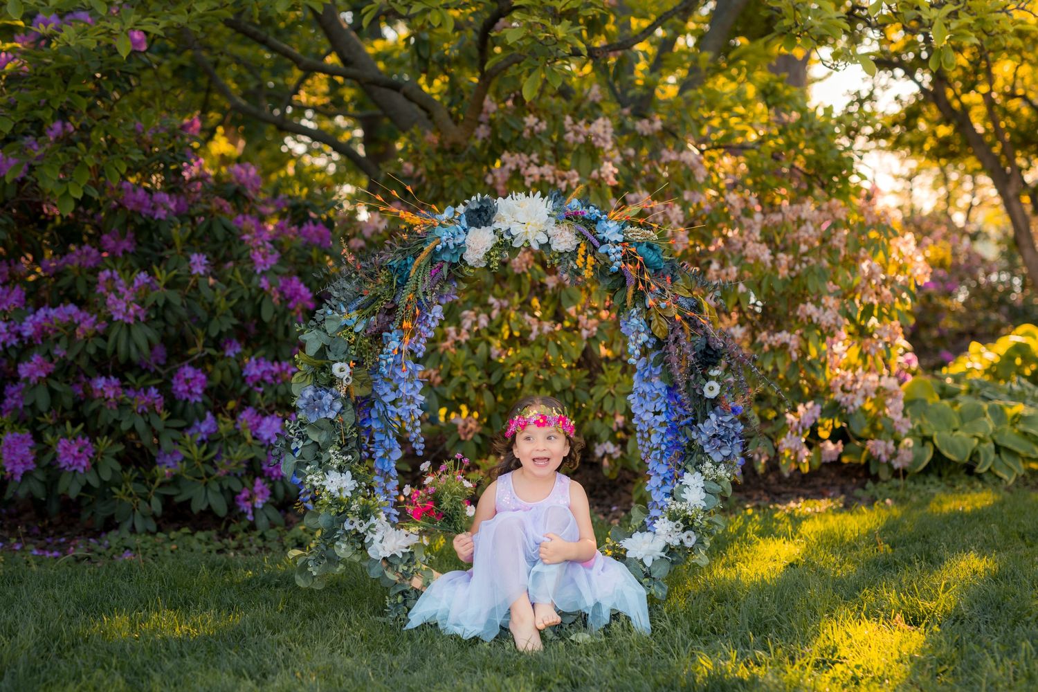 Young girl holding a colorful bouquet surrounded by vibrant flowers in Amherstburg.