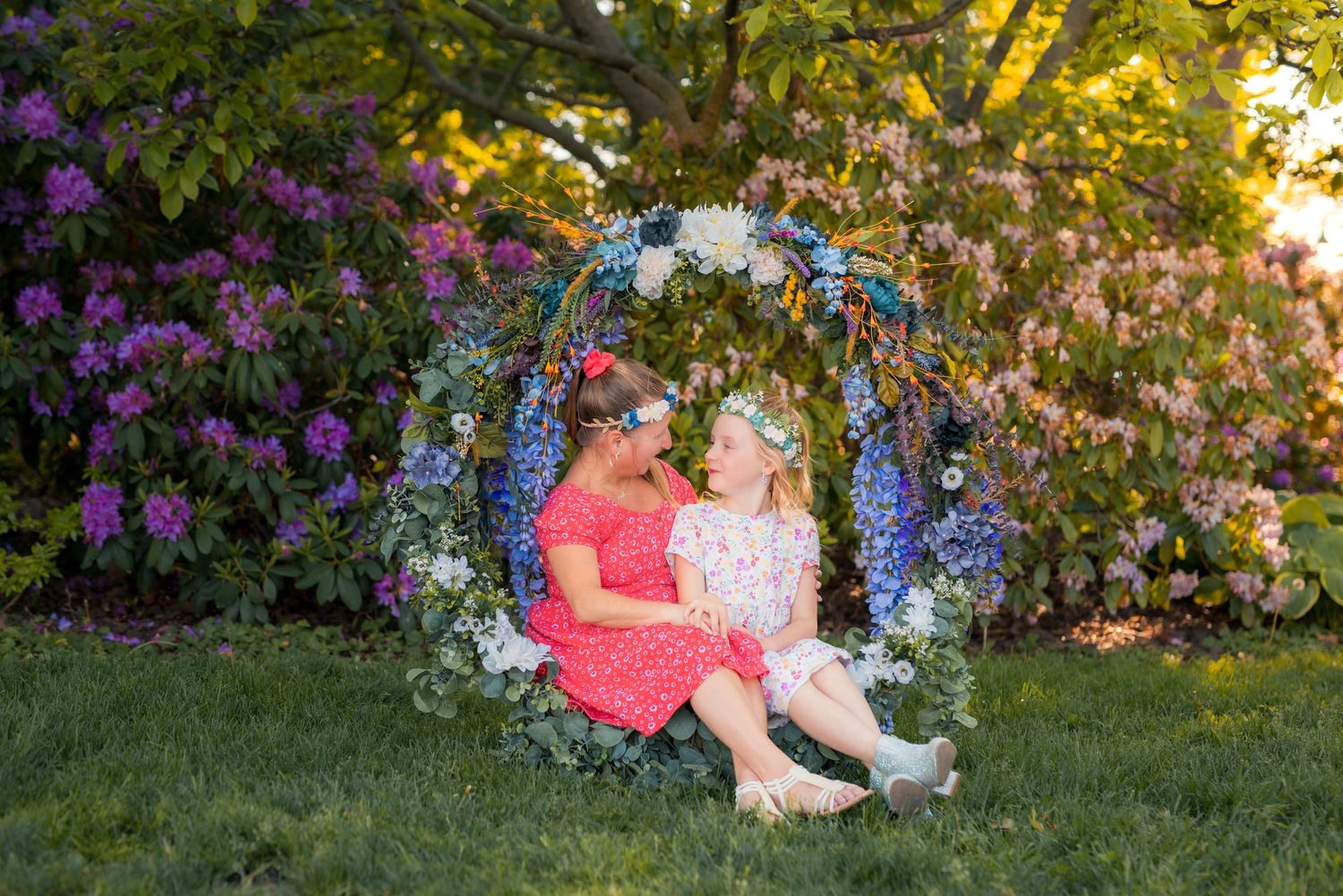 Golden hour mother and daughter portrait surrounded by vibrant flowers at Kings Navy Yard Park.