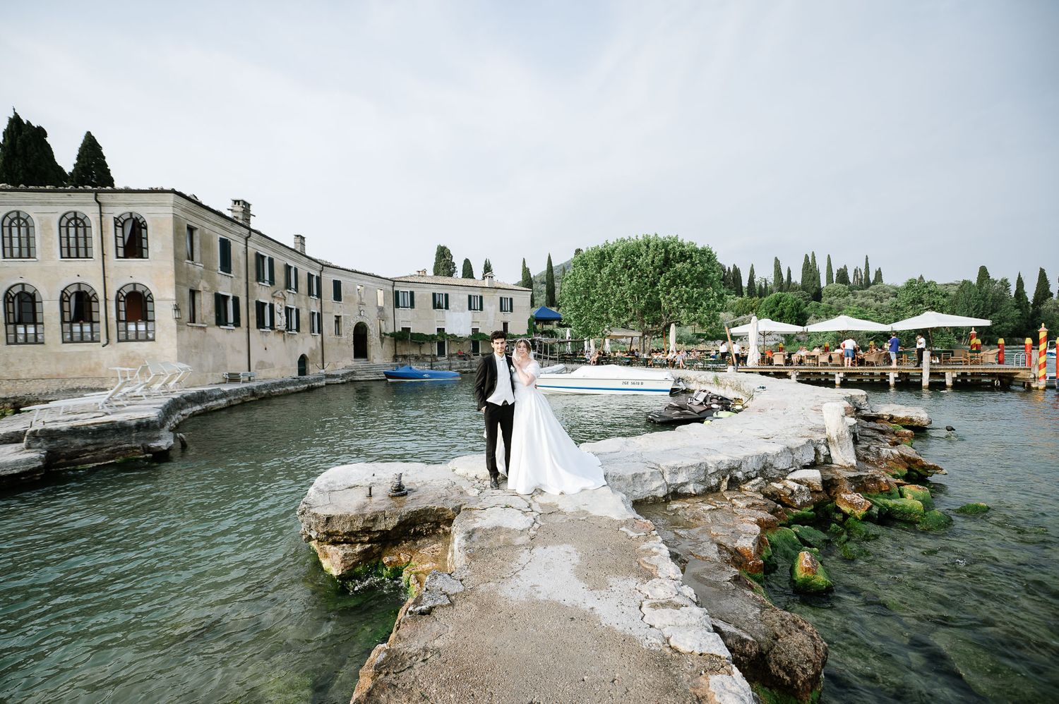 Bride and groom embracing during sunset wedding portrait on Lake Garda, Punta San Vigilio Italy