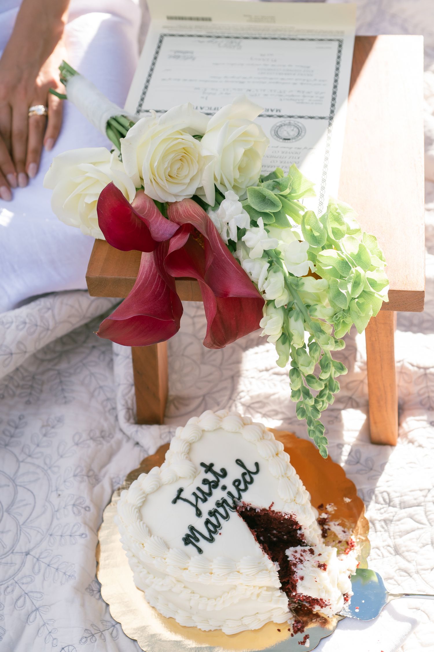 A Just Married red velvet wedding cake beside a bridal bouquet for a cute Colorado elopement at Officer's Gulch