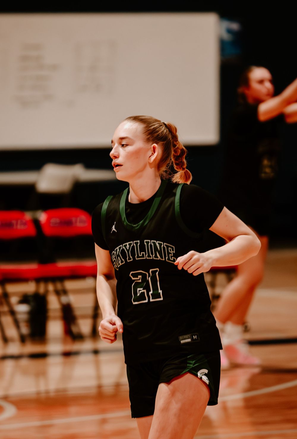Player in black jersey practices defensive sliding drills during basketball training.