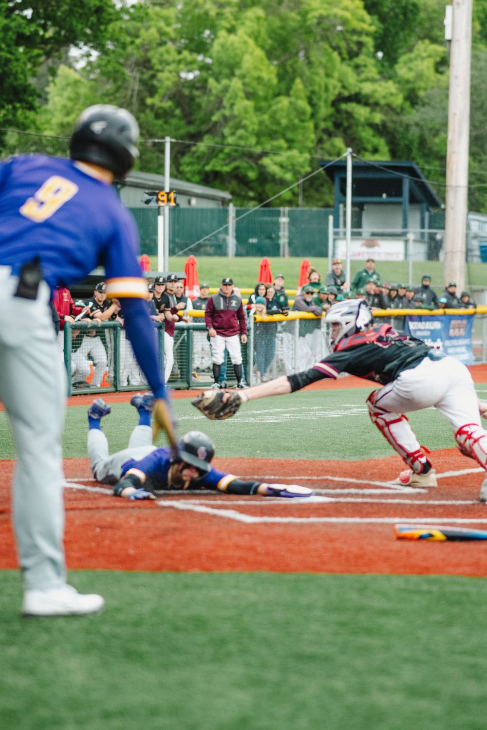 Baseball play at home plate with catcher attempting to make a tag.