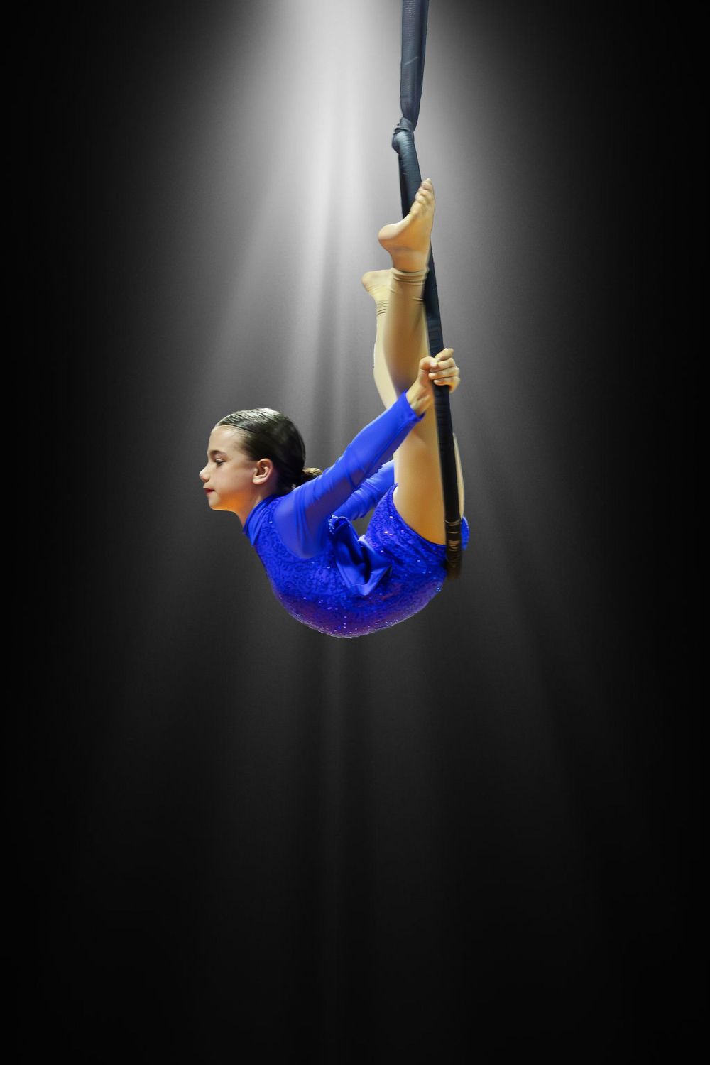 Focal Point Images
Aerial performer in blue costume executes elegant pose on suspended equipment.