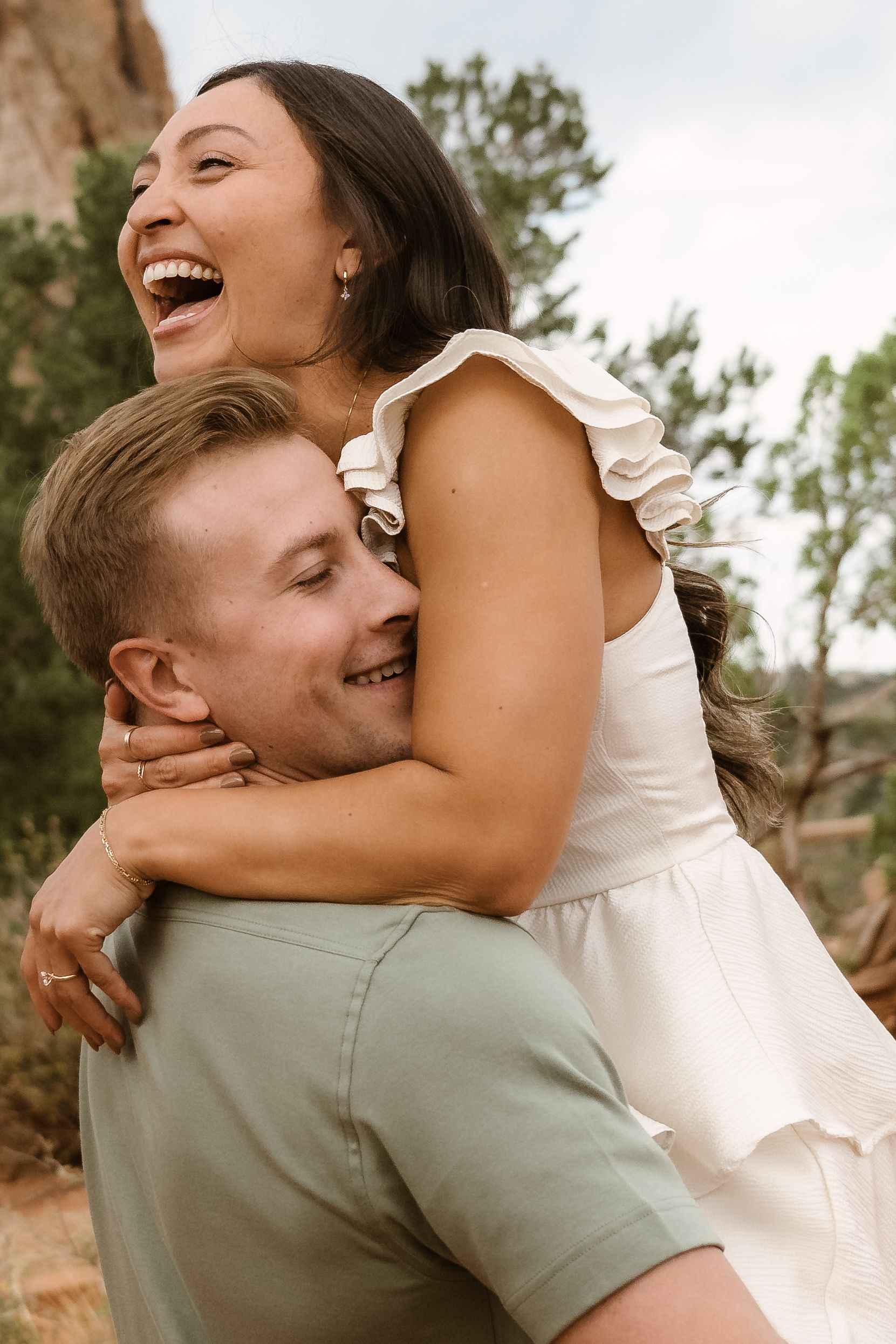 A joyful couple shares intimate laughing moments during their wedding photo session.