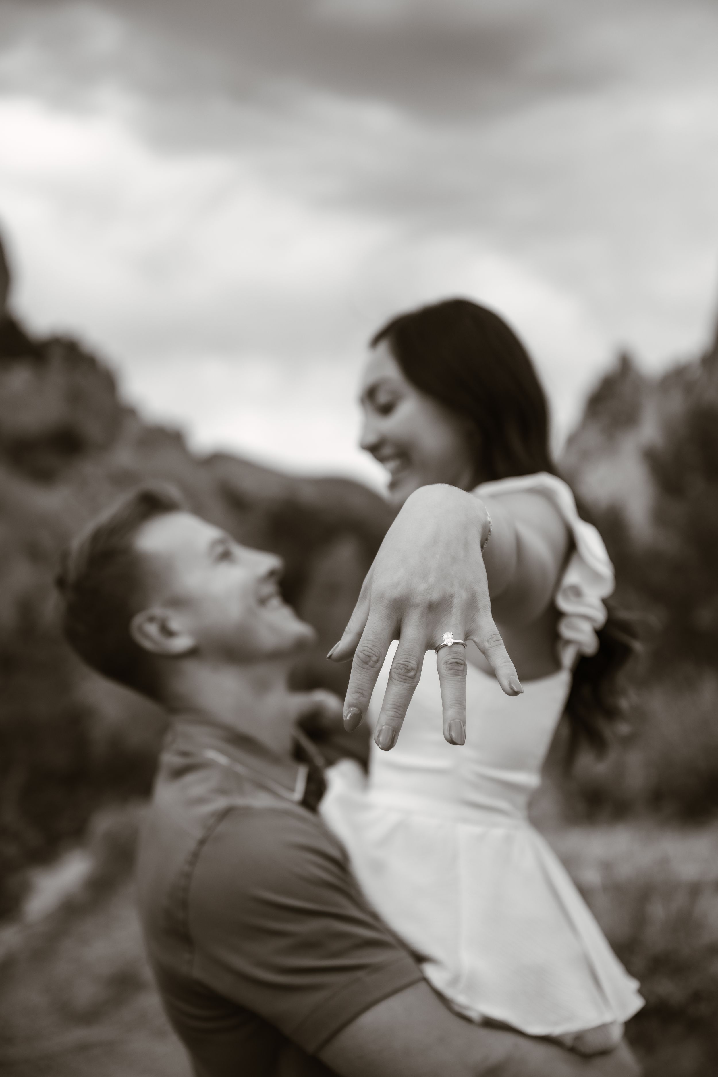 A romantic black and white moment captured as a couple leans in close together.