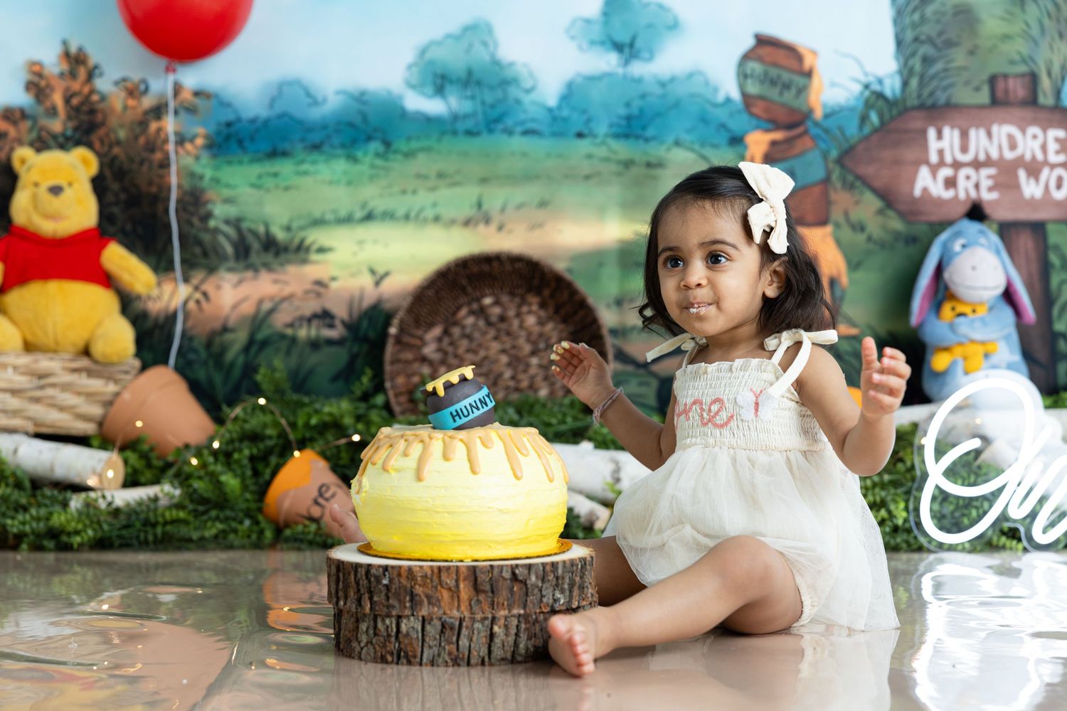 Celebration scene with child, yellow cake, and Winnie the Pooh decorations.