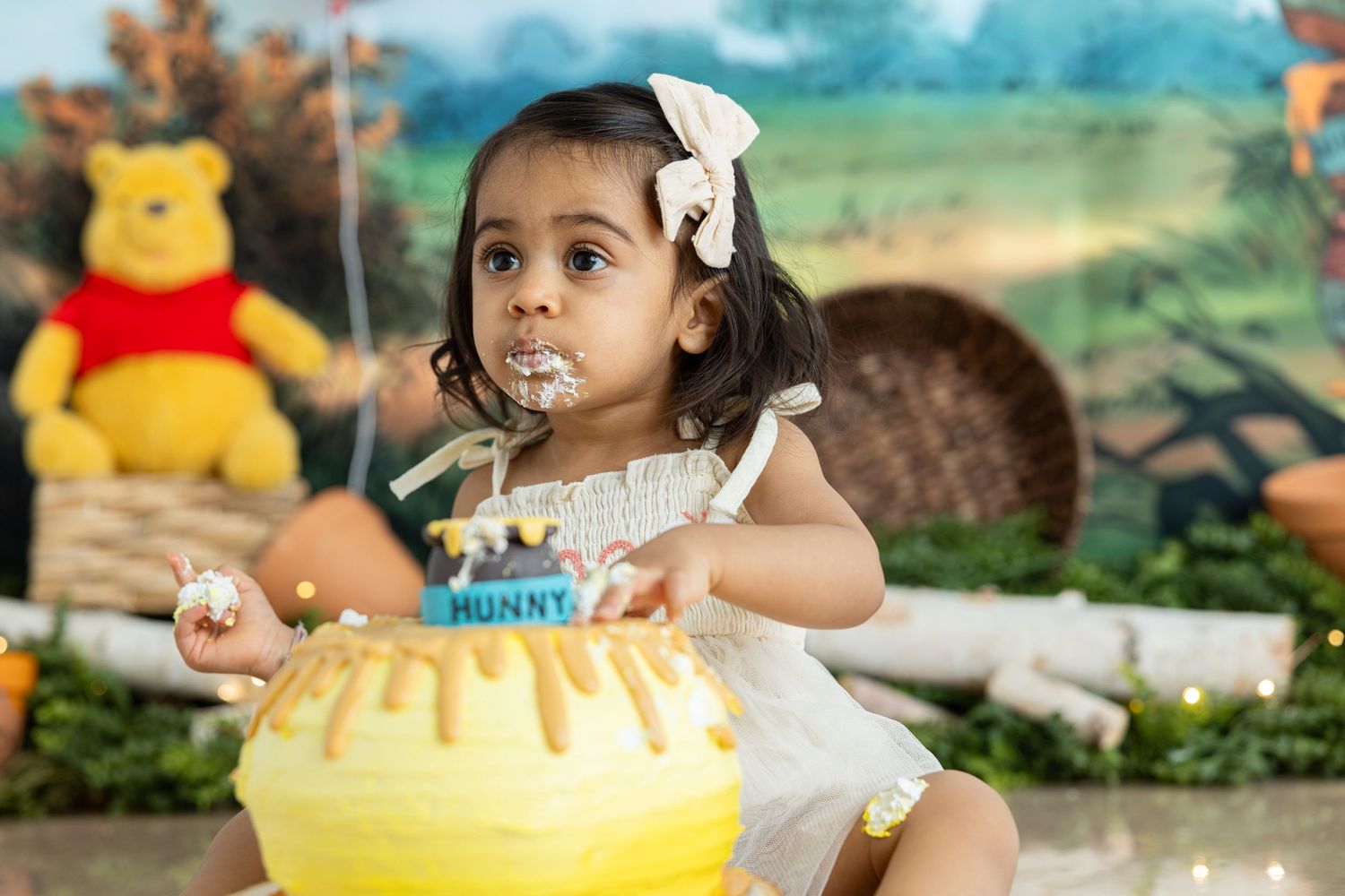 Close-up of child enjoying cake at Winnie the Pooh themed party.