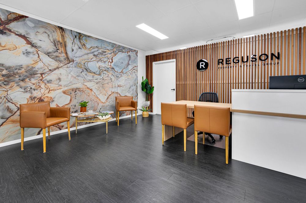 Modern office lobby with wood paneled walls, sleek reception desk, and contemporary seating arrangements.